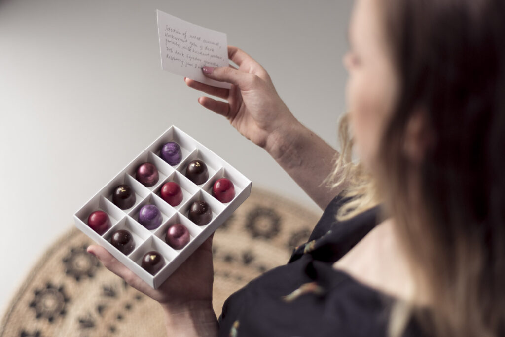 Woman holding chocolate gifts open