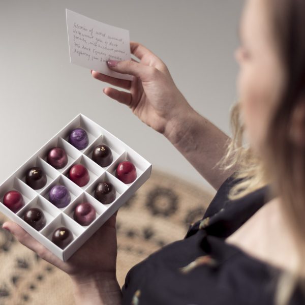 Woman holding chocolate gifts open